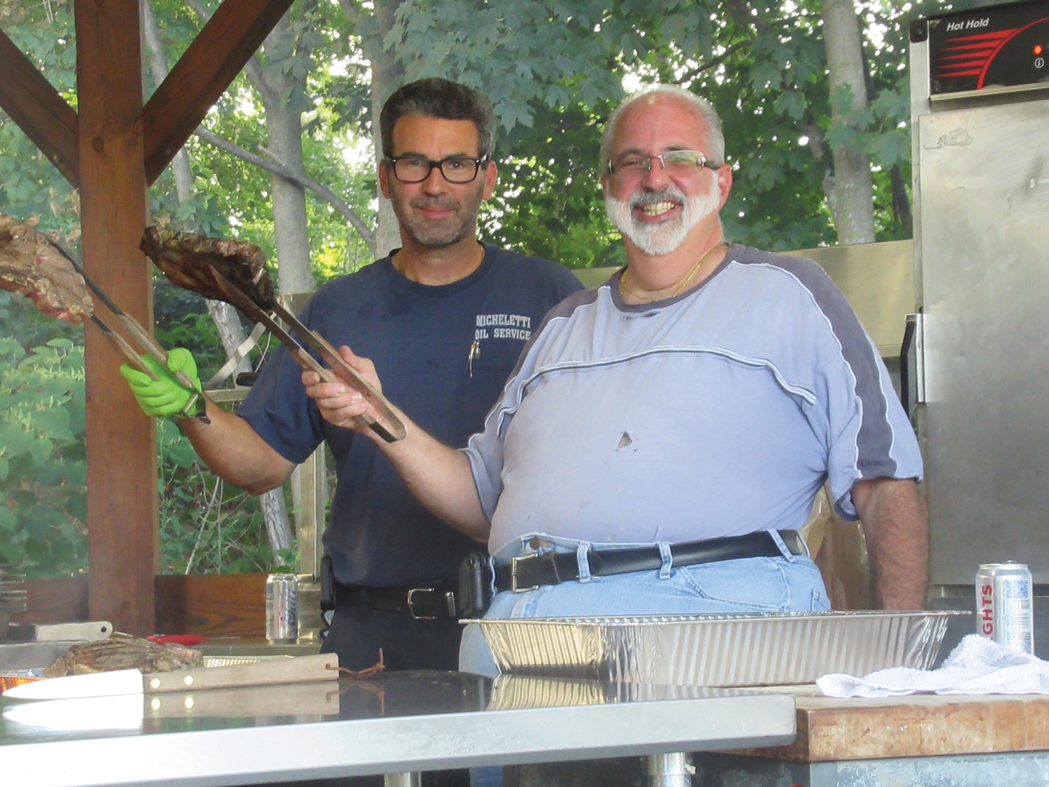GRILL GUYS: Joe Micheletti and Mike Lombardi hold up two of the more than 160 two-pound steaks they cooked Saturday night at the OLG Fest and Festival kickoff.